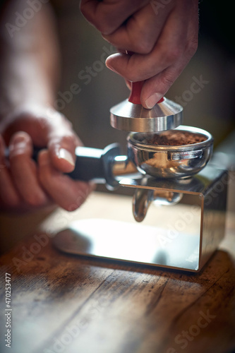 Close-up view of a barman's hands using accessories for preparing an espresso. Coffee, beverage, bar