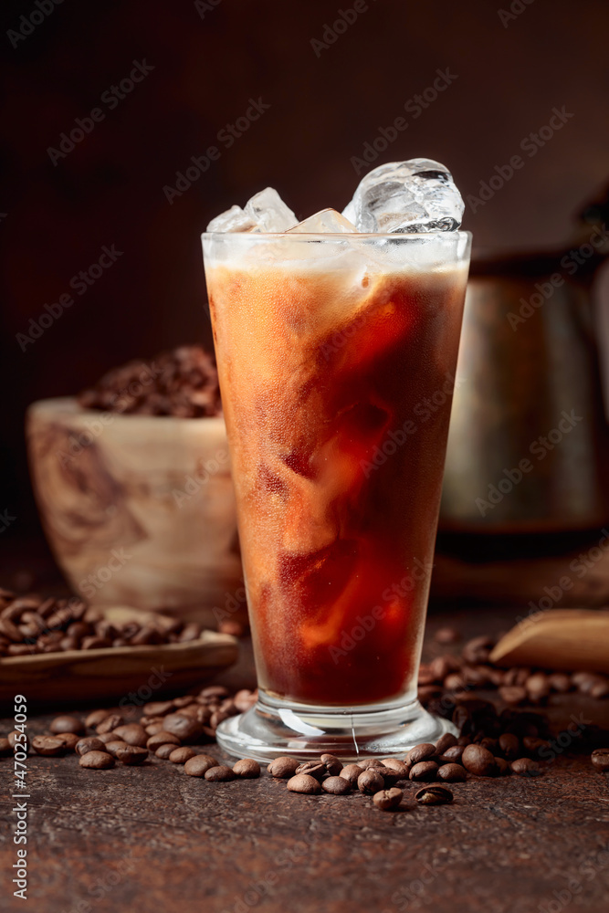 Ice coffee with cream being poured into it showing the texture and refreshing look of the drink. Ice coffee with cream being poured into it showing the texture and refreshing look of the drink.
