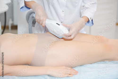 Close up shot of a girl on a cosmetology chair during the procedure of laser hair removal of the bikinia zone