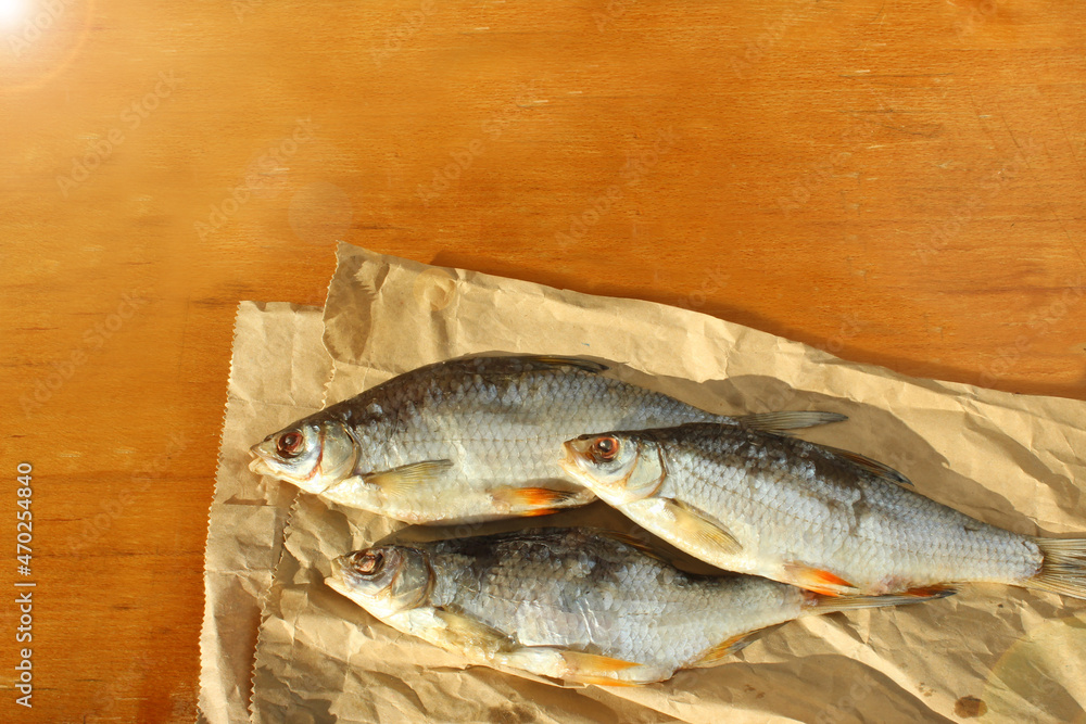 Dried dried fish for beer on a wooden table. Seafood on brown paper Dried dried fish for beer on a wooden table. Seafood on brown paper