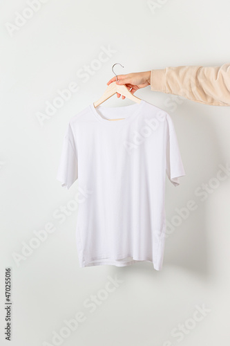 White t-shirt mockup in woman hand. Bella canvas mock up in minimal style.