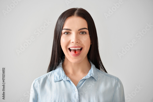 Young woman taking pill on ...