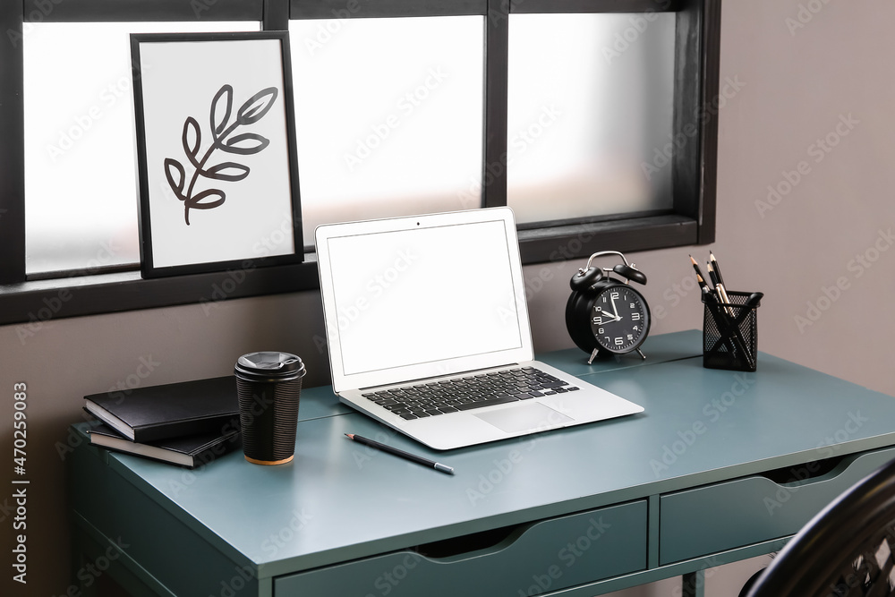 Fototapeta premium Comfortable workplace with laptop near window in interior of room