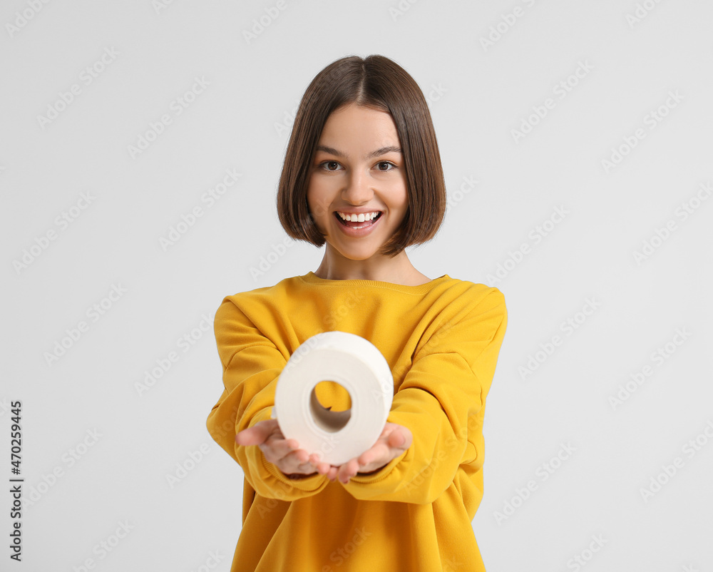 Young woman with toilet paper on light background Young woman with toilet paper on light background