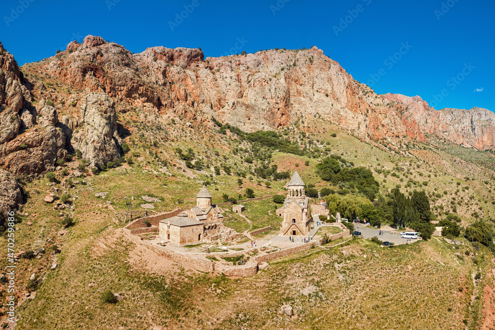 Naklejka premium Aerial view of famous Noravank monastery with two churches located in a picturesque mountain gorge with red rocks. Popular place and travel excursions in Armenia