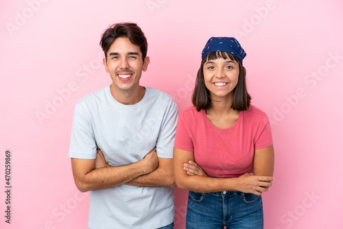 Young couple isolated on pink background keeping the arms crossed while smiling © luismolinero
