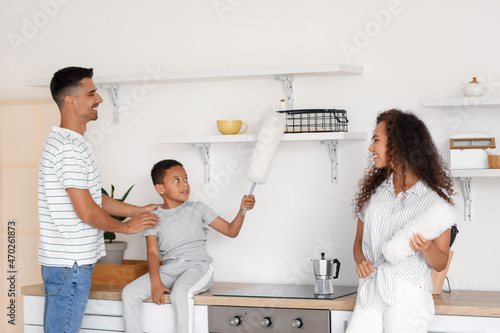 Happy family cleaning kitch...