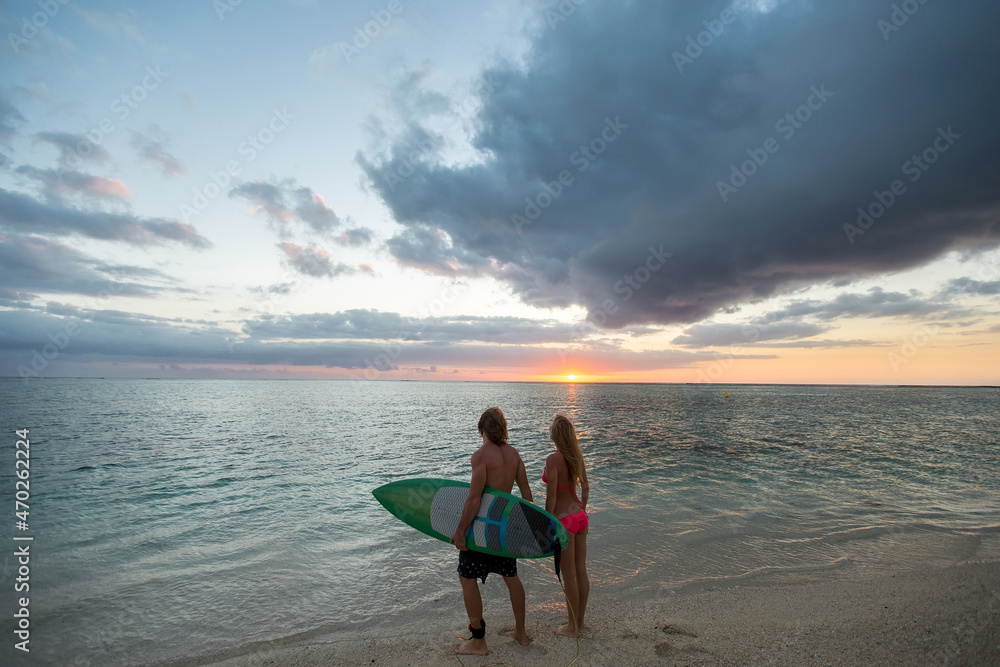 Obraz premium Man and a Woman with Surf Boards at Sunset