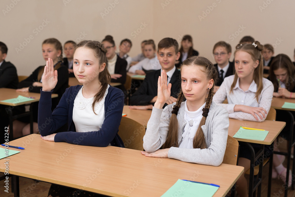 Happy schoolchildren sit at a desk in the classroom Happy schoolchildren sit at a desk in the classroom