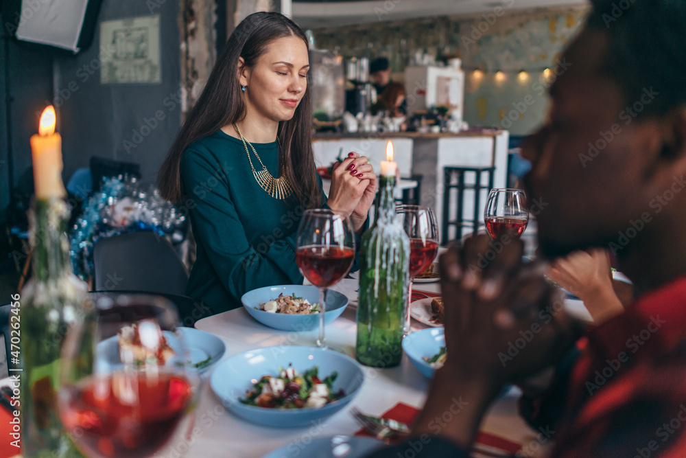 Friends Saying Prayer Before Eating Meal Together.