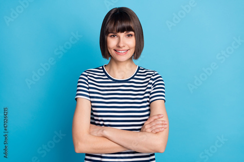 Photo of cheerful young positive woman hold hands crossed good mood isolated on blue color background