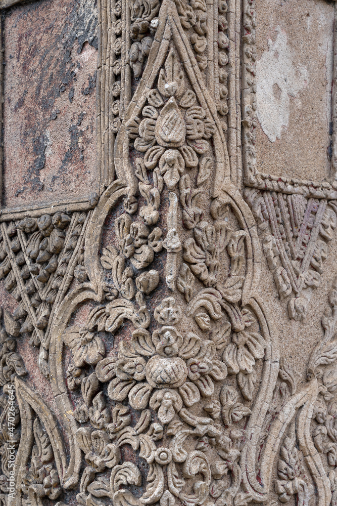 Detail of beautiful ancient stucco decoration with traditional Lanna Thai floral motif on exterior of historic hor trai library in Wat Duang Dee or Duang Di, Chiang Mai, Thailand