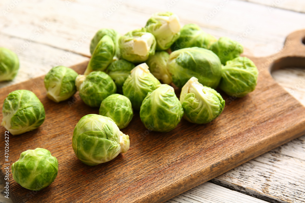 Board with fresh raw Brussels cabbage on light wooden background, closeup Board with fresh raw Brussels cabbage on light wooden background, closeup