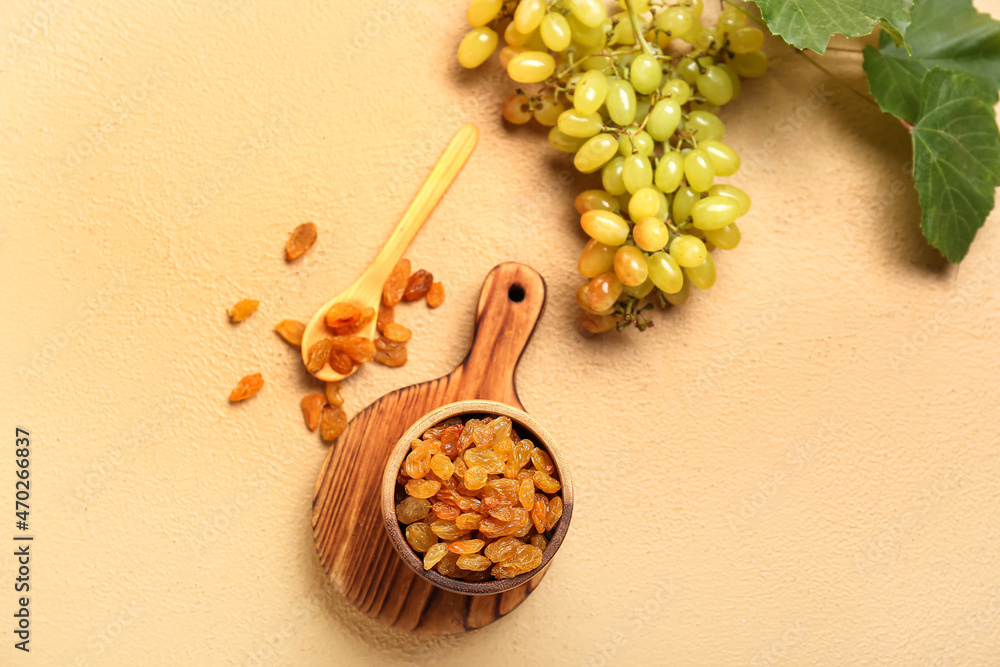 Bowl with tasty raisins and fresh grapes on color background Bowl with tasty raisins and fresh grapes on color background