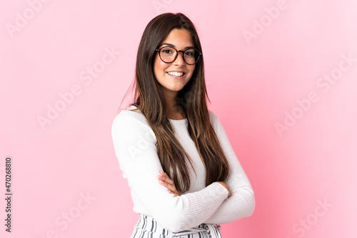 Young brazilian woman isolated on pink background with arms crossed and looking forward