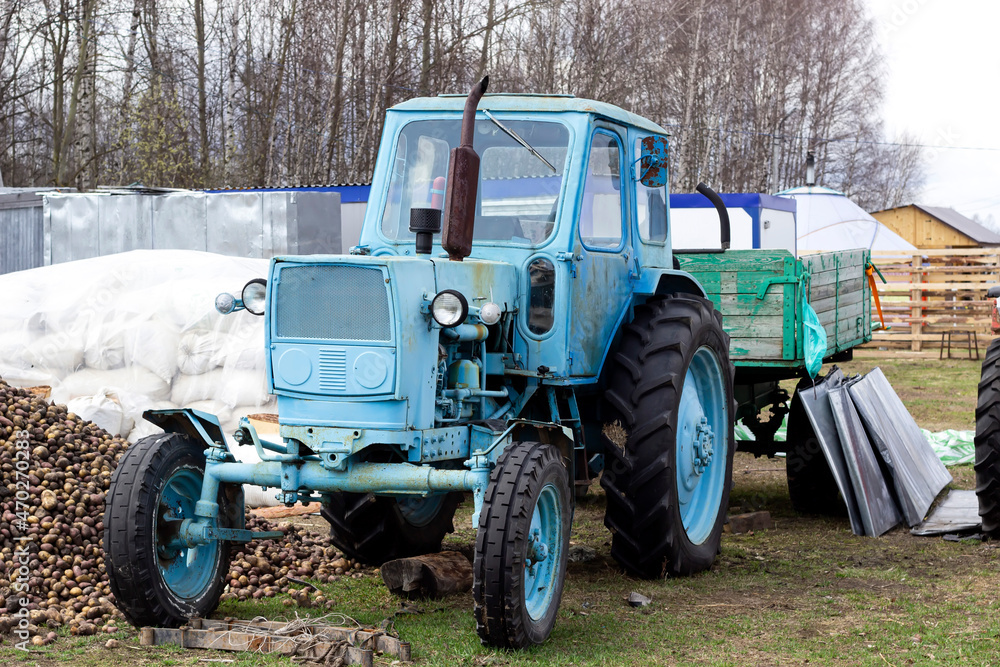 Old blue tractor stands in the village. Old blue tractor stands in the village.