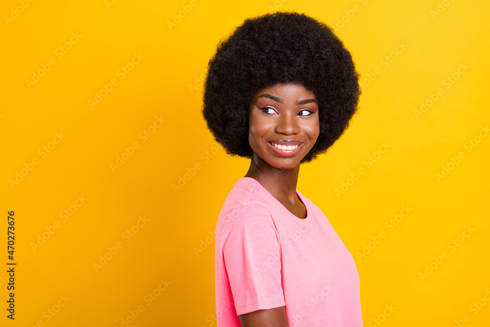 Profile side photo of young cheerful black girl happy positive smile look empty space isolated over yellow color background Profile side photo of young cheerful black girl happy positive smile look empty space isolated over yellow color background