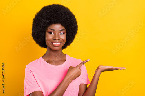 Photo of young black girl happy positive smile point finger advert product select suggest isolated over yellow color background