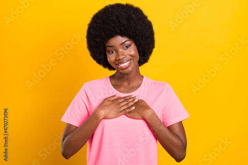 Photo of young adorable afro girl happy positive smile hand on chest appreciate grateful isolated over yellow color background