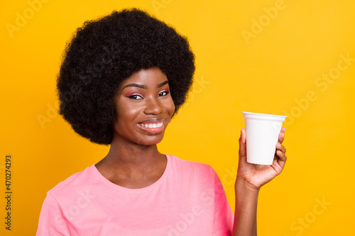 Photo of young black girl happy positive smile show advise suggest pomo food product isolated over yellow color background photo