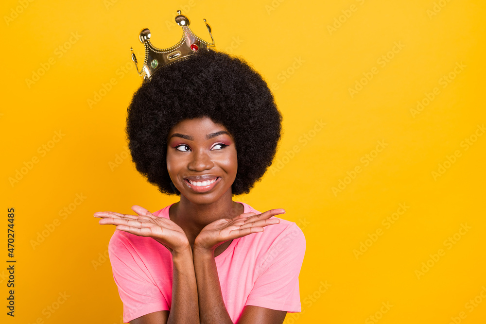 Photo of charmiing young lady look empty space hands face wear crown pink t-shirt isolated on yellow color background Photo of charmiing young lady look empty space hands face wear crown pink t-shirt isolated on yellow color background