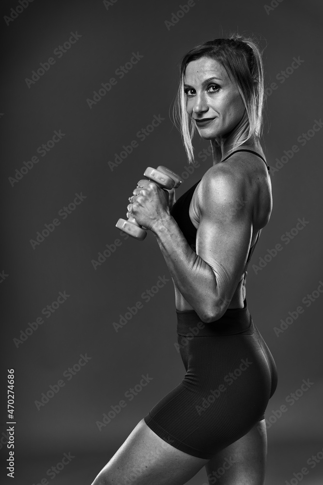 Fototapeta premium Female bodybuilder working out, black and white