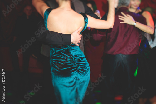 Couples dancing traditional latin argentinian dance milonga in the ballroom, tango salsa bachata kizomba lesson in the red lights, dance festival