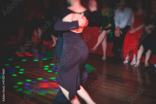 Couples dancing traditional latin argentinian dance milonga in the ballroom, tango salsa bachata kizomba lesson in the red lights, dance festival