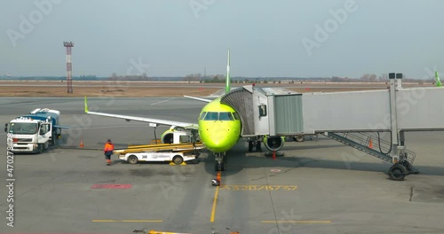 Timelapse: ground staff preparing aircraft before flight, refueling, loading baggage, food for flight services. Jet stand at air terminal gate photo