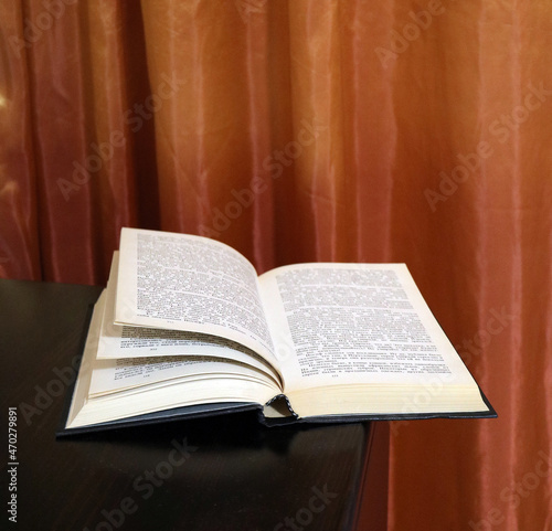 open book on the table against the background of curtains
