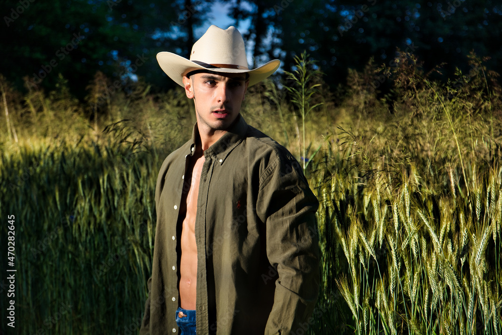 Sexy farmer or cowboy with unbuttoned shirt