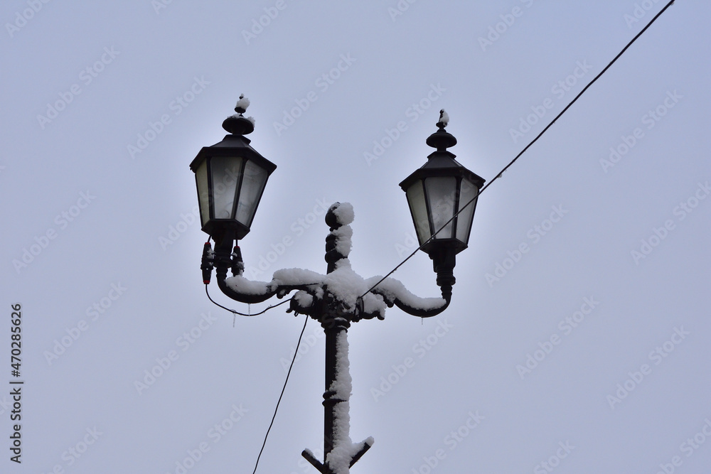 Street lamp against the cloudy sky covered with snow on a winter day. Winter. Street lamp against the cloudy sky covered with snow on a winter day. Winter.