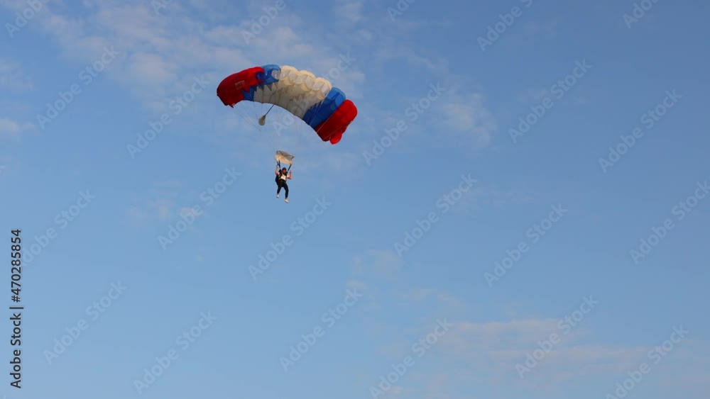 Ecka, Vojvodina, Serbia - August 21, 2021 National Parachuting Championship: Parachutist is flying slowly down with an open parachute. Skydiving, gliding, parachute jump Ecka, Vojvodina, Serbia - August 21, 2021 National Parachuting Championship: Parachutist is flying slowly down with an open parachute. Skydiving, gliding, parachute jump