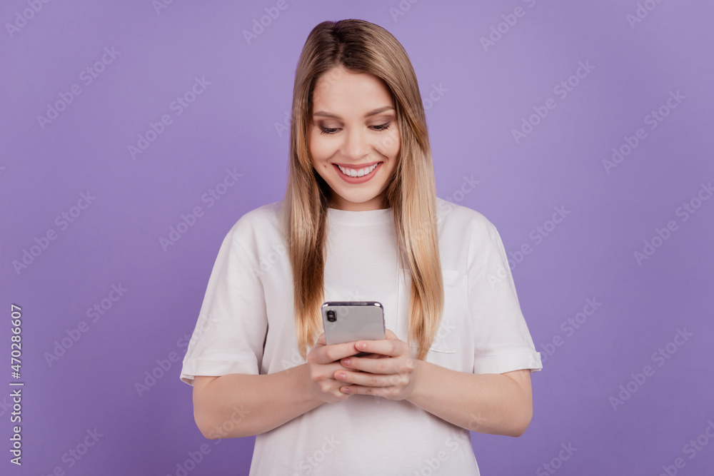 Photo of blogger influencer lady hold telephone texting friends wear casual t-shirt on violet background Photo of blogger influencer lady hold telephone texting friends wear casual t-shirt on violet background