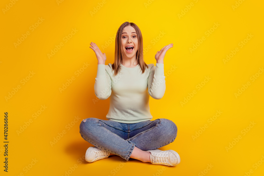 Photo of excited shocked funky lady sit floor omg reaction wear green shirt jeans isolated on yellow background Photo of excited shocked funky lady sit floor omg reaction wear green shirt jeans isolated on yellow background