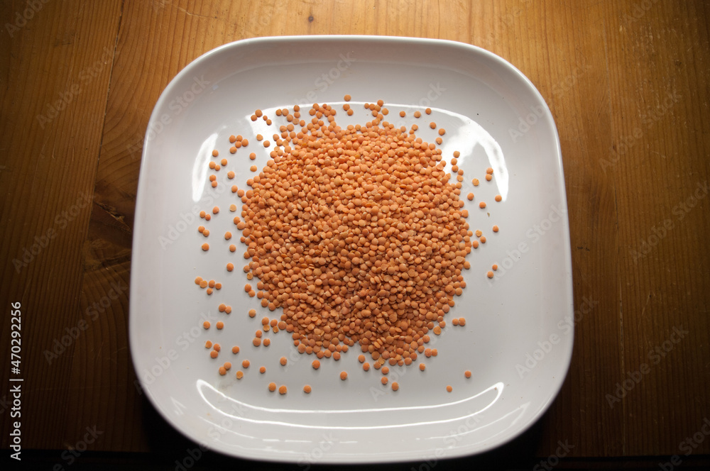 White plate with red lentils, cropped, close up
