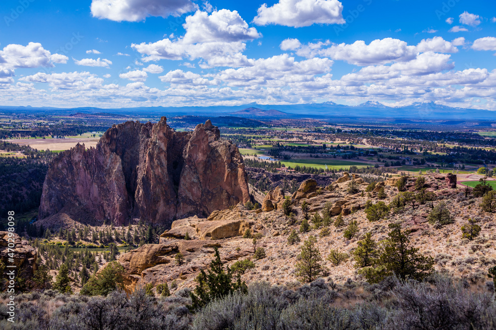Amazing landscape. Beautiful rocks in the foreground. Colorful valley between the mountains. High mountains with snow on the horizon. Smith Rock state park, Oregon