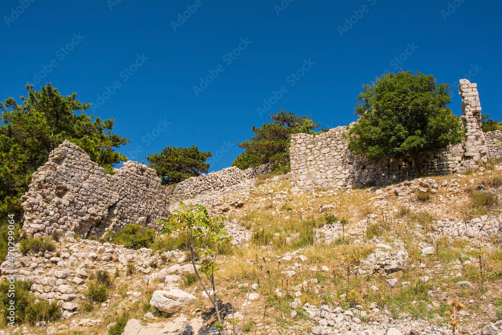 The ruins of the medieval Baska Citadel, Kastel Baska, overlooking the south Krk island town of Baska in the Primorje-Gorski Kotar County of western Croatia
