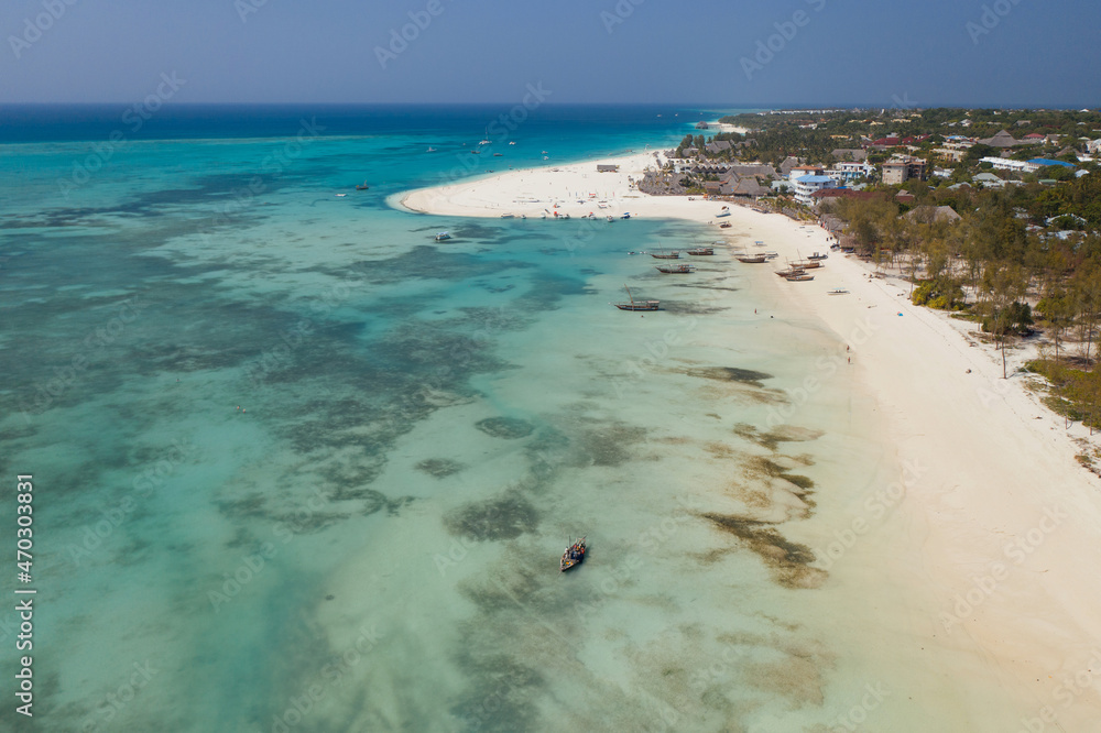 Tropical island of Zanzibar, Tanzania. Bay with fishing boats docked in azure water