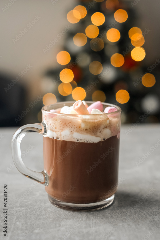 hot cocoa with marshmallows in a glass transparent cup on the background of a Christmas tree. cozy atmosphere. holiday hot cocoa with marshmallows in a glass transparent cup on the background of a Christmas tree. cozy atmosphere. holiday
