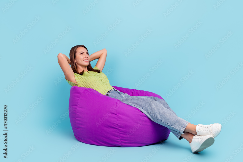 Obraz premium Full body profile photo of rest brunette young lady sit on bag wear t-shirt jeans shoes isolated on blue color background