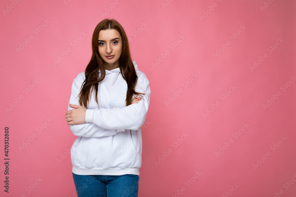Young self-confident sttractive brunette woman with sincere emotions isolated on background wall with copy space wearing casual stylish light colour hoodie looking at camera Young self-confident sttractive brunette woman with sincere emotions isolated on background wall with copy space wearing casual stylish light colour hoodie looking at camera