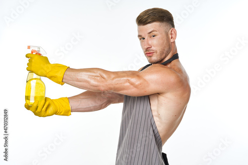 pumped up man in an apron with rubber gloves detergents