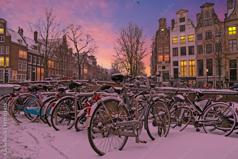 Snowy bikes in Amsterdam the Netherlands at sunset