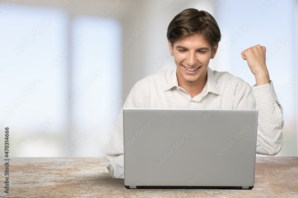 Excited man emotionally celebrating success using laptop in home office, Excited man emotionally celebrating success using laptop in home office,