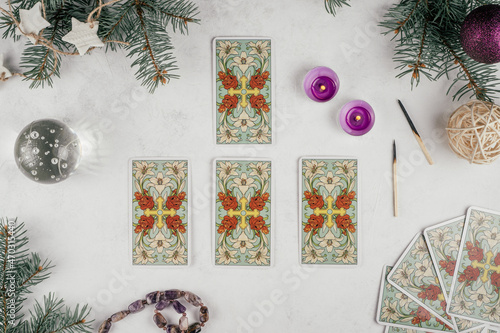 Tarot cards spread on white concrete surface with Christmas tree branches and candles. Minsk, Belarus, 19.11.2021