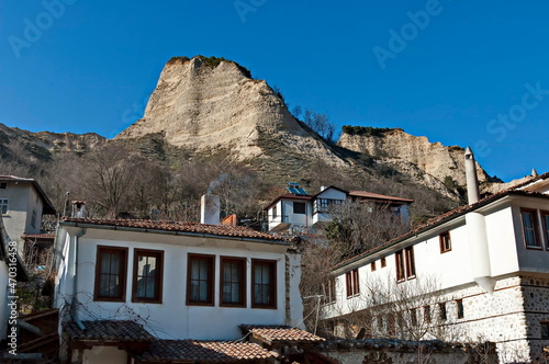 Old traditional houses against the backdrop of the famous sand pyramids in the town of Melnik, Bulgaria  photo