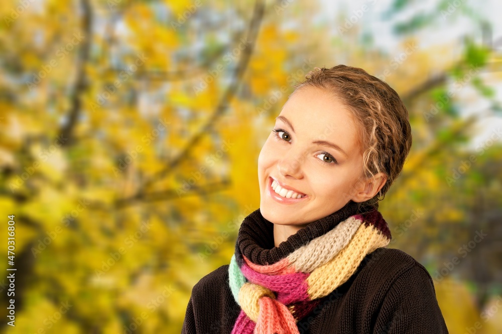 Carefree young woman wearing scarf at park during autumn season. Carefree young woman wearing scarf at park during autumn season.