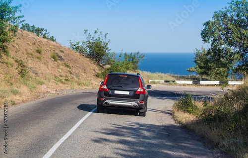 Car Moves Along Winding Road to the Sea