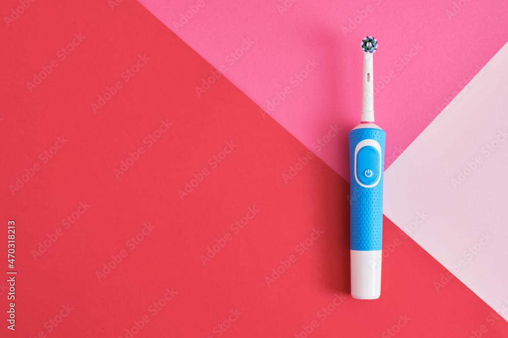 electric blue toothbrush on geometric pink and blue background oral hygiene concept copy space electric blue toothbrush on geometric pink and blue background oral hygiene concept copy space